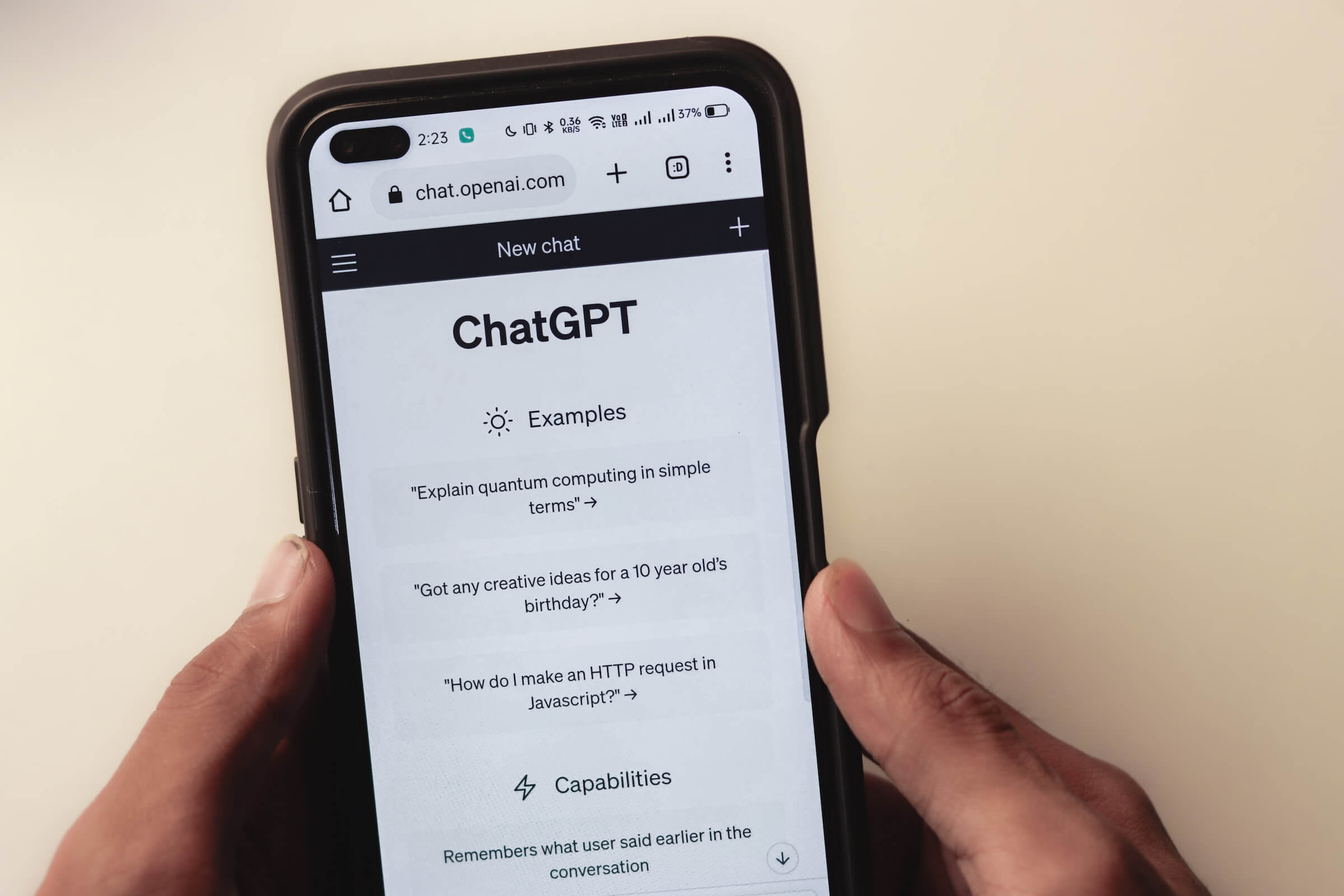 A person holding a phone with the screen open to Chat GPT and some prompts.